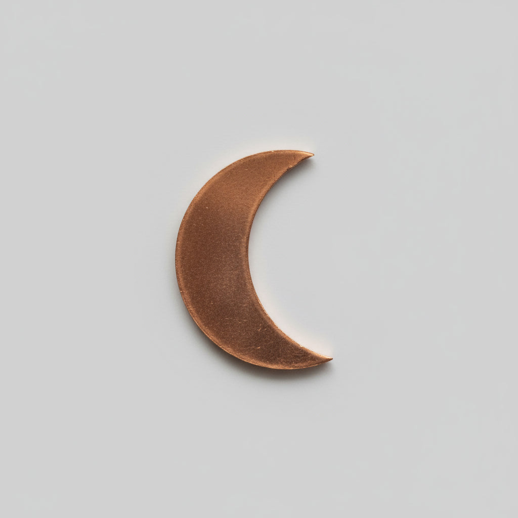 An electrolytic copper celestial shaped as a medium moon, placed on a measuring scale background.