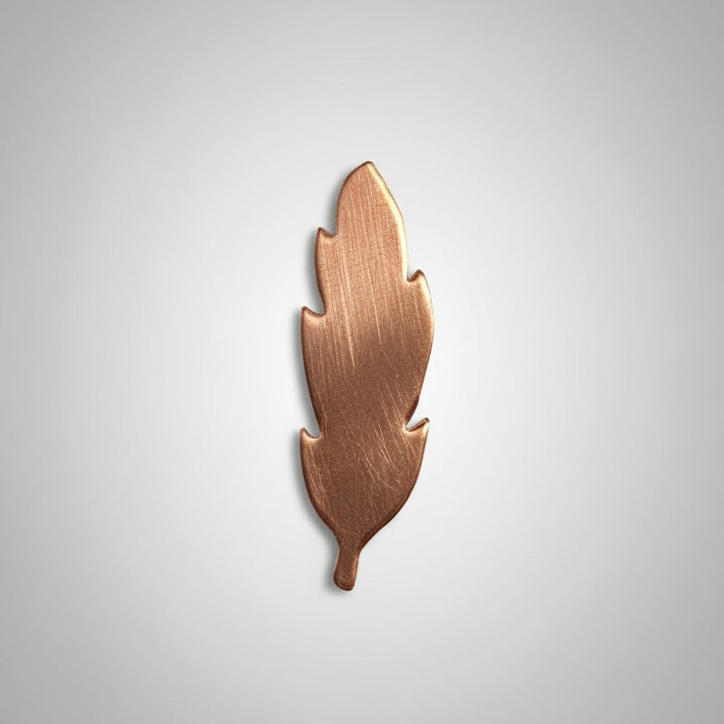 Copper feather-shaped object on a black grid background