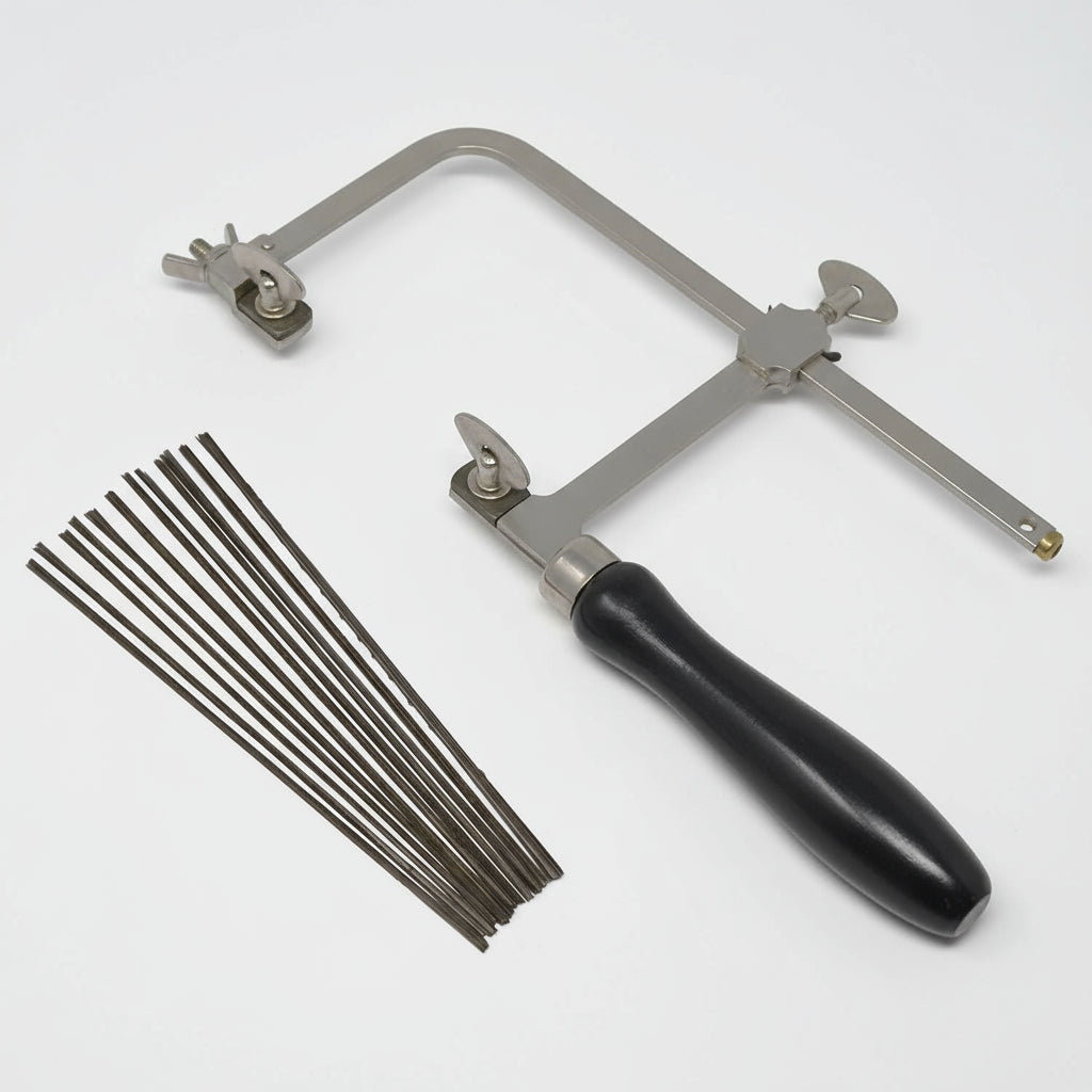 A jeweler's saw with an adjustable frame and multiple saw blades, featuring a black handle and silver-colored metal parts.