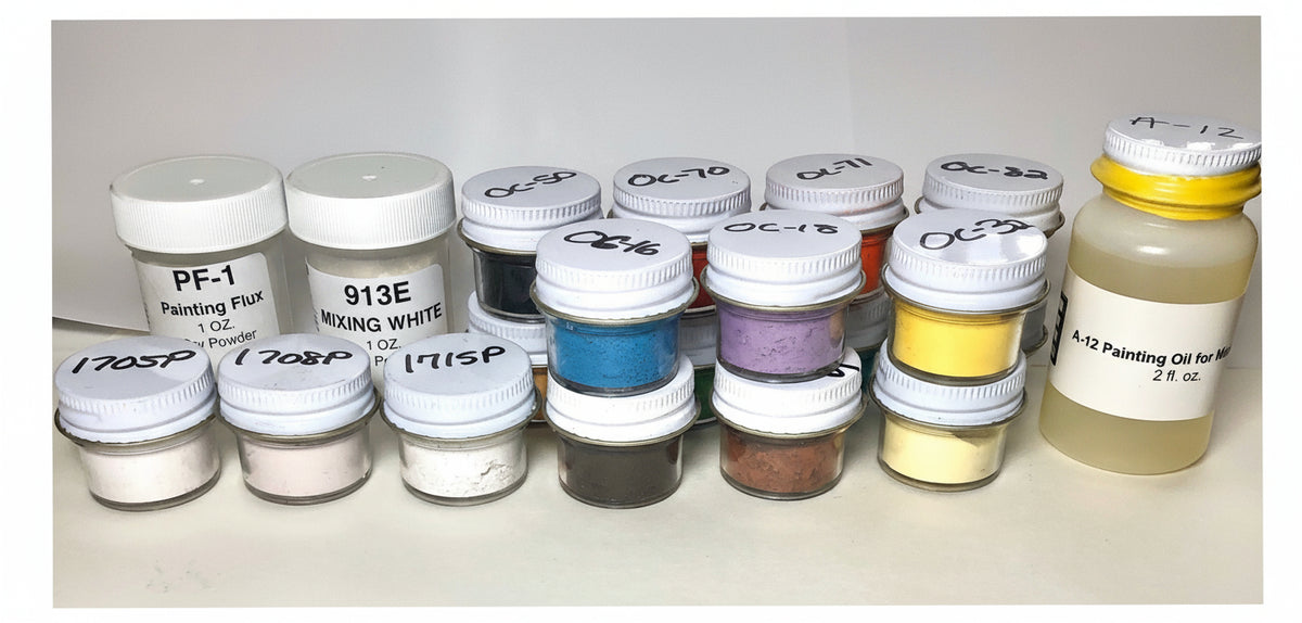 An array of paint jars and a bottle of painting oil, labeled with various color names and numbers, indicating a variety of enamel colors for miniature painting.