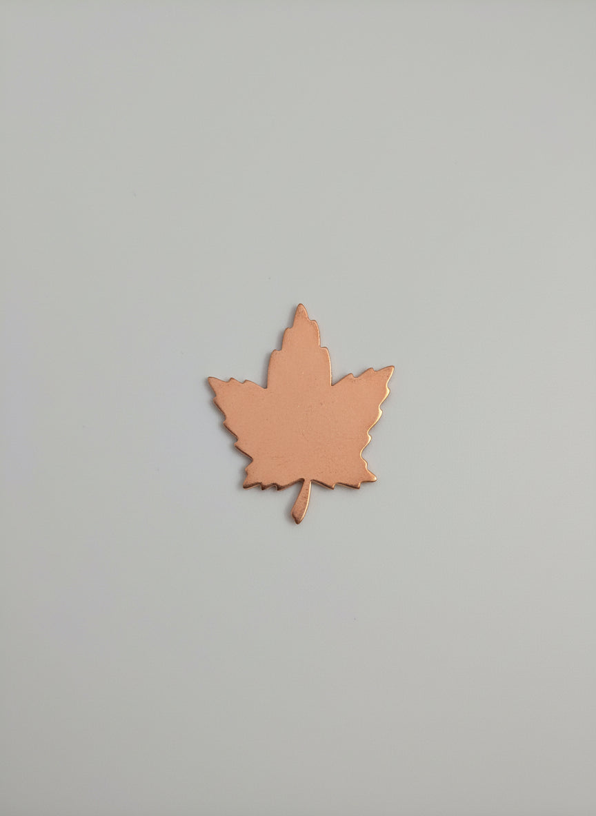 Copper leaf-shaped object on a black grid background
