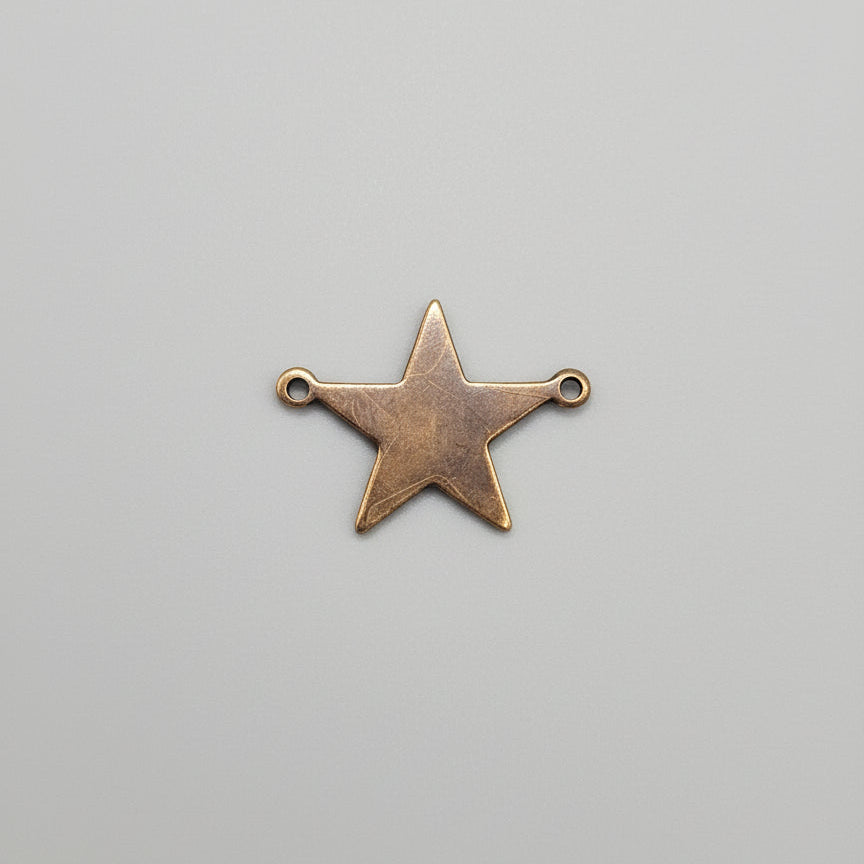 Copper star-shaped pendant on a gray background