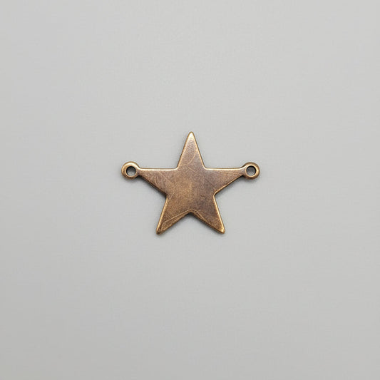 Copper star-shaped pendant on a gray background