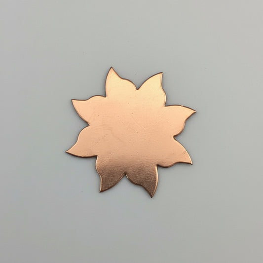 Copper Sun leaf-shaped object on a black grid background