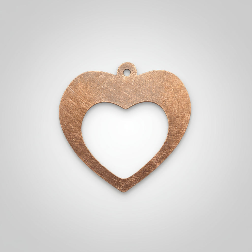 Copper heart-shaped pendant on a black background with measurement scale