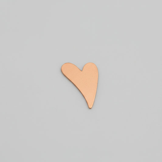 Heart-shaped object on a grid ruler for scale