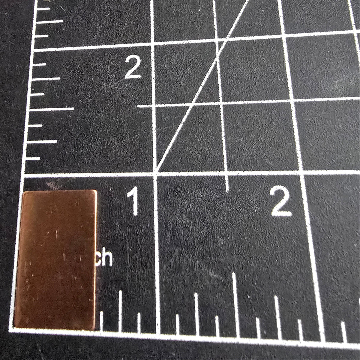 Small rectangular metal object on a grid cutting mat