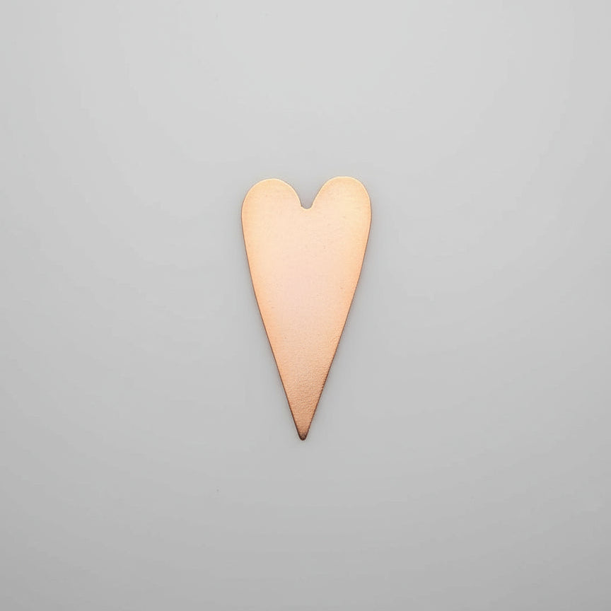 Copper heart-shaped object on a gray background